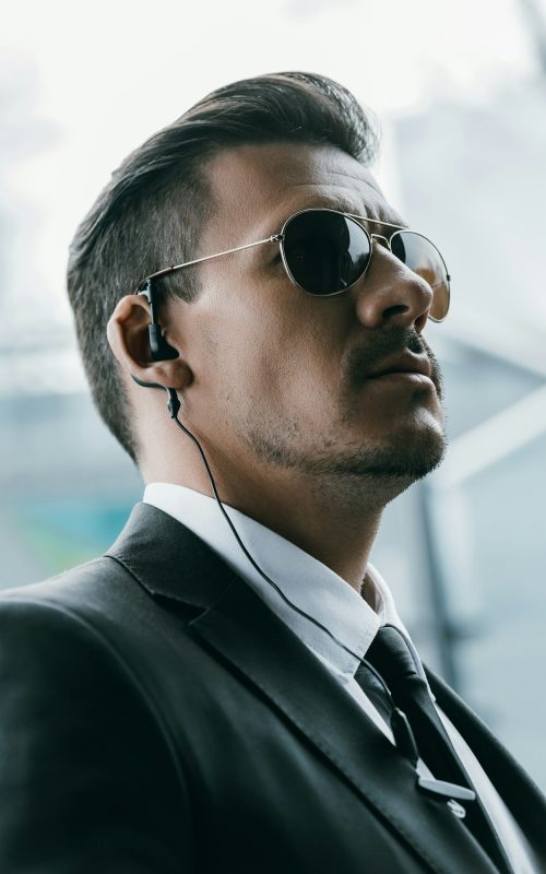 portrait of handsome security guard in sunglasses and security earpiece